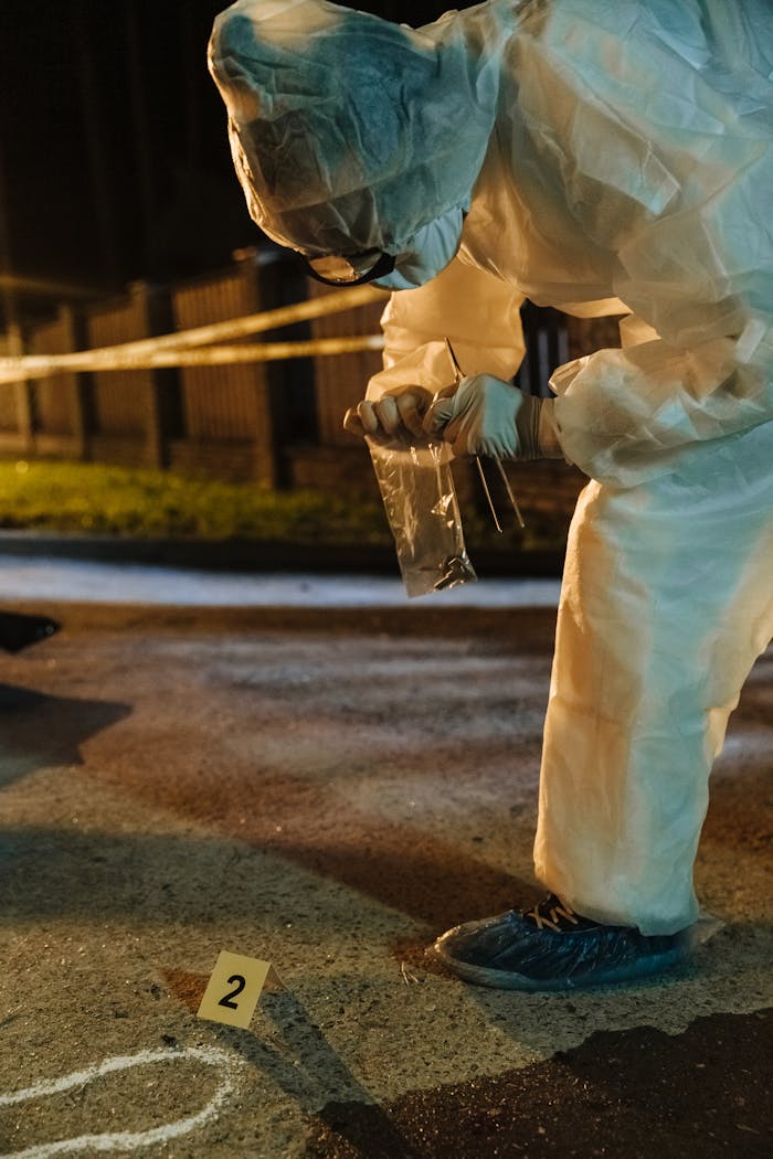 services-img A forensic investigator collects evidence at a crime scene during nighttime.