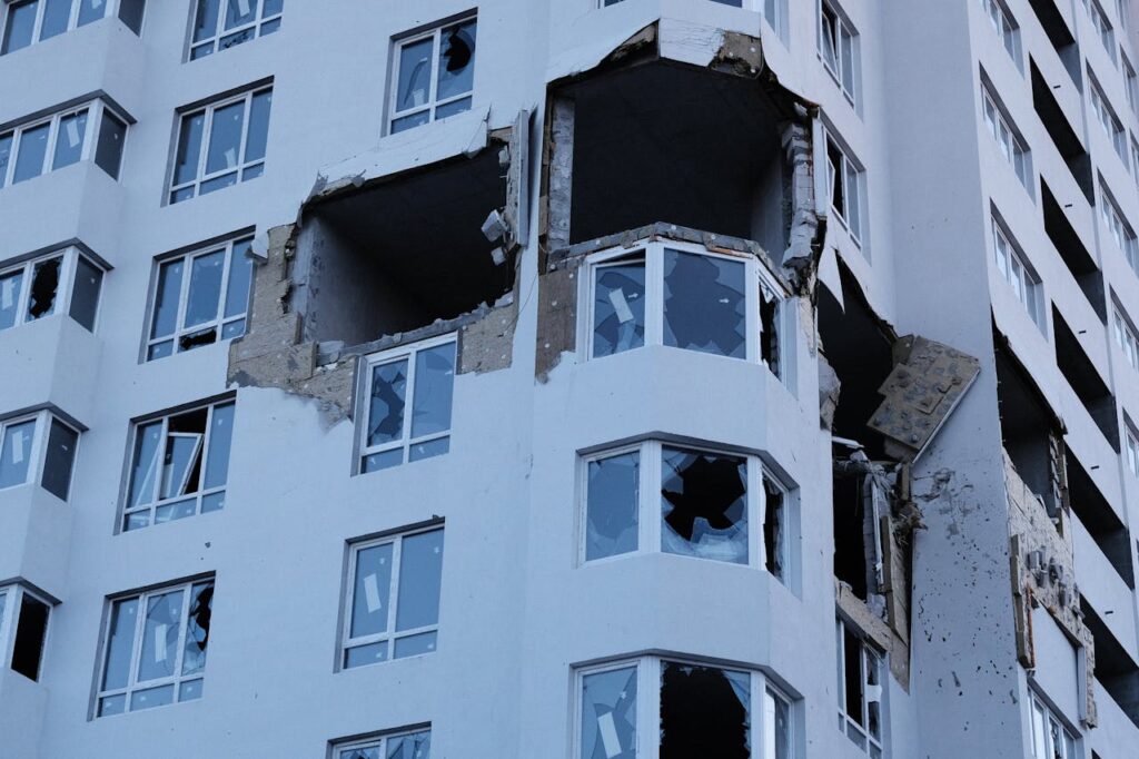 A high-rise building in Ukraine with significant structural damage and shattered windows.